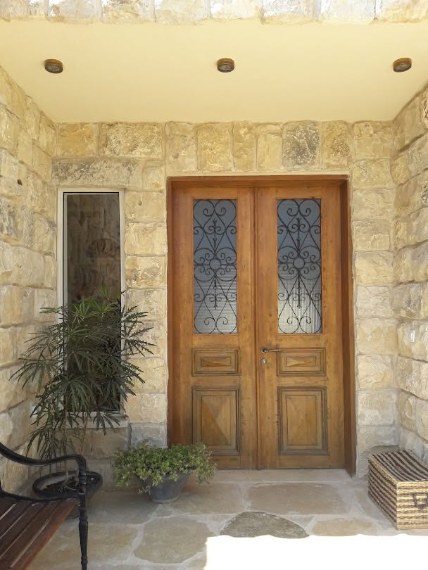 כניסה לבית עם מנורת קיר פנסית ליד הדלת