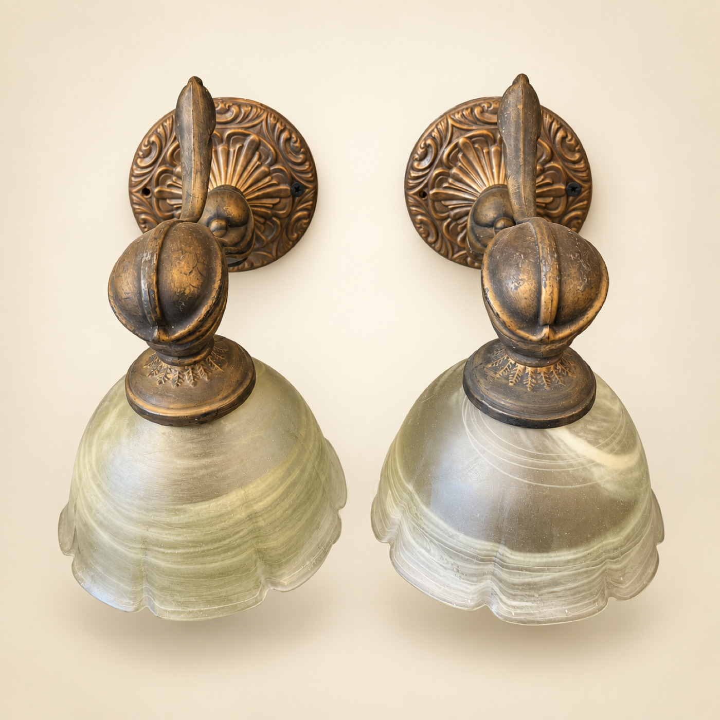 Pair of Bronze-Tone Wall Sconces with Ornate Round Backplates and Frosted Greenish-White Glass Shades with Scalloped Rims — K69 — Angle 1